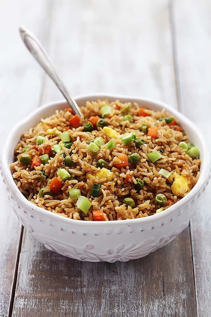 close up of a bowl of fried rice and a spoon.