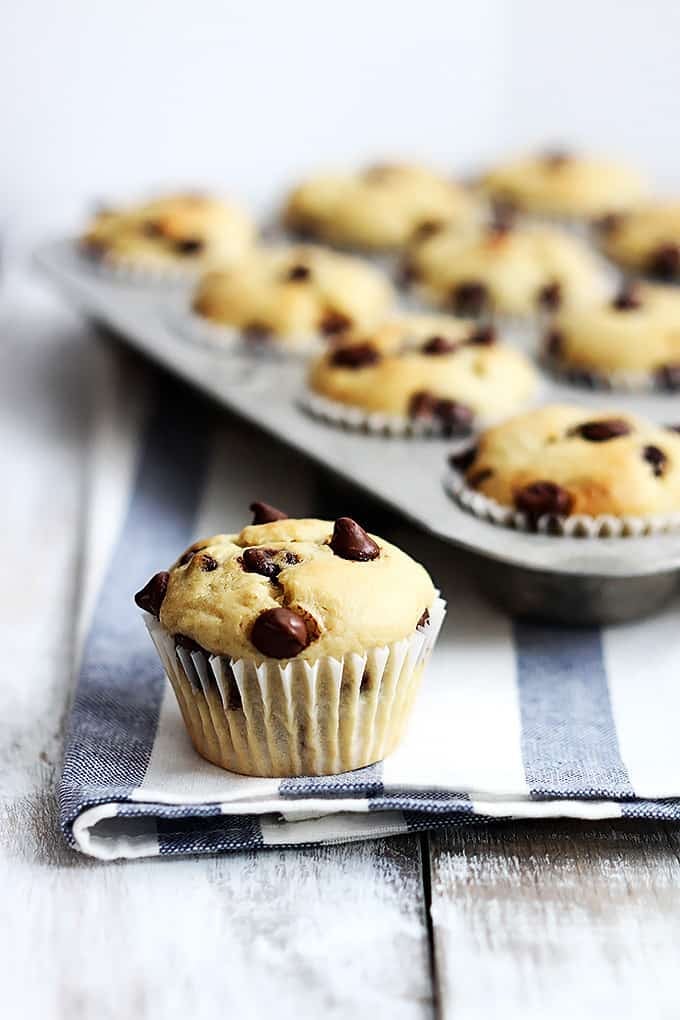 a greek yogurt muffin with more muffins in a muffin tin in the background.