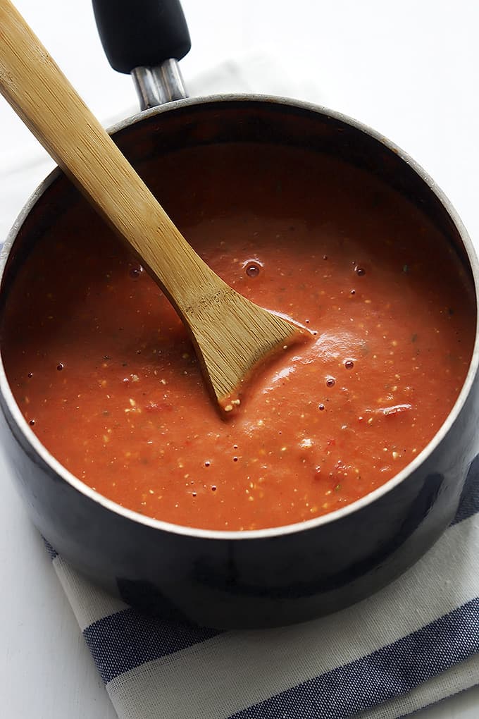 roasted red pepper sauce with a wooden serving spoon in a pan.