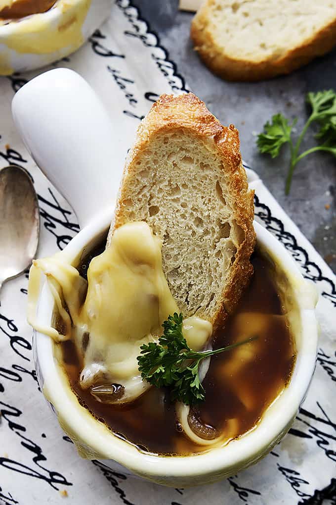 top view of French onion soup and a slice of bread in a bowl.