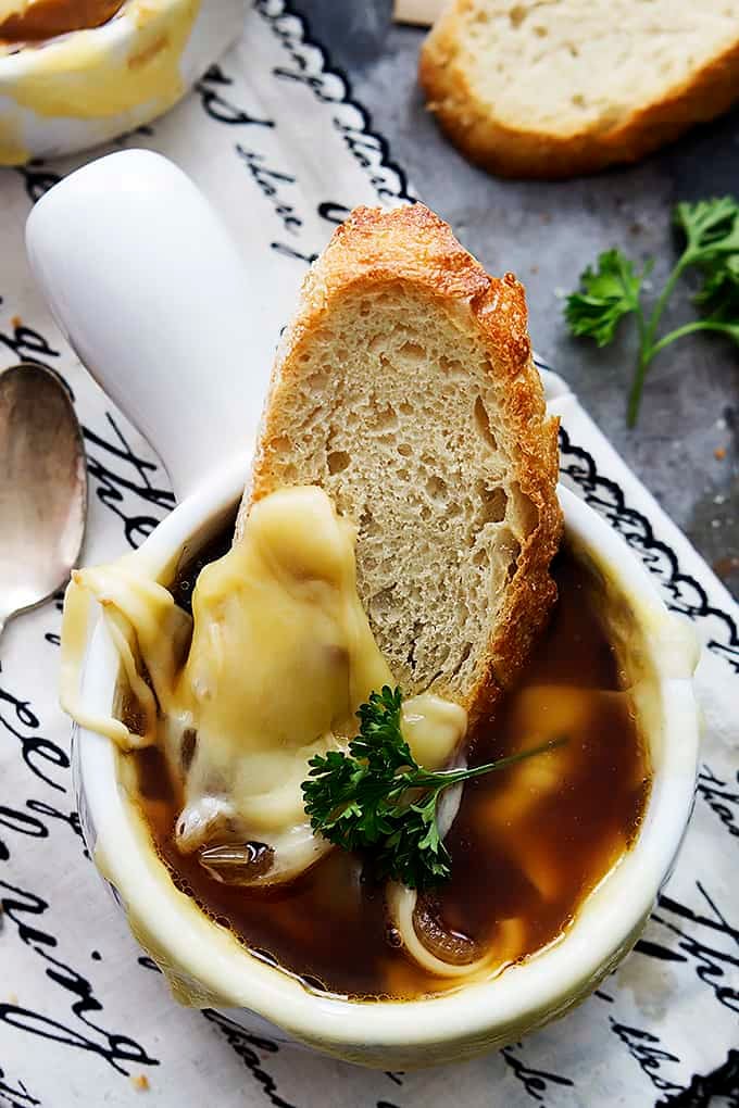 top view of French onion soup and a slice of bread in a bowl.