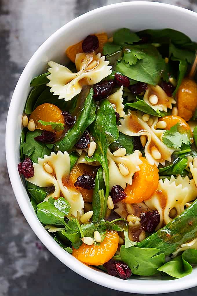 top view of mandarin pasta spinach salad with teriyaki dressing in a bowl.