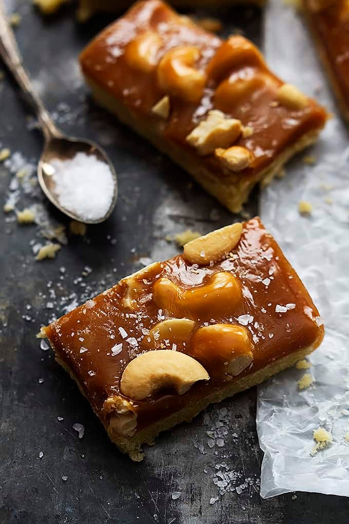 caramel cashew shortbread bars with a spoon of salt on the side.