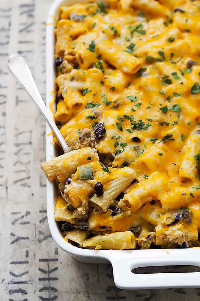 cheesy Mexican rigatoni bake with a spoon in a serving dish.