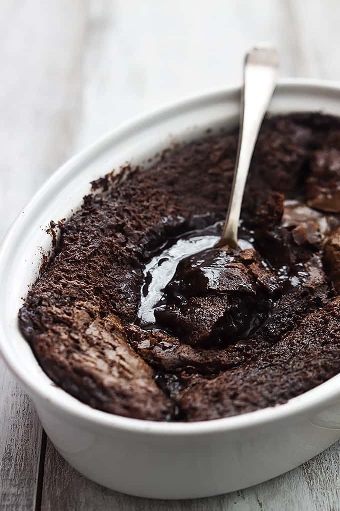 chocolate cobbler with a spoon in a serving bowl.