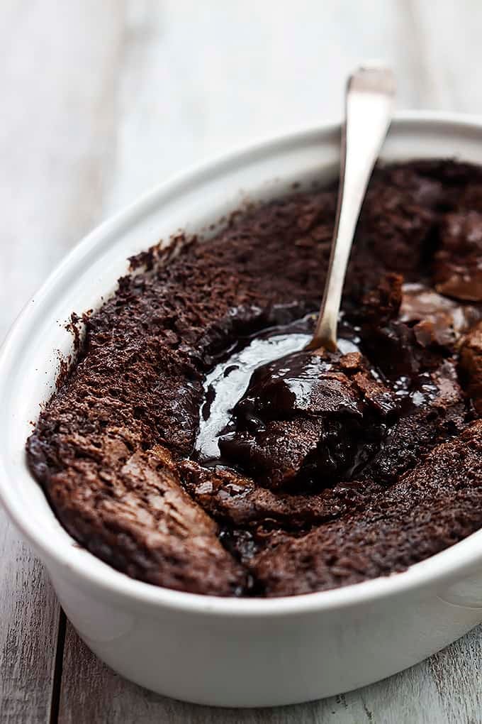 chocolate cobbler with a spoon in a serving bowl.