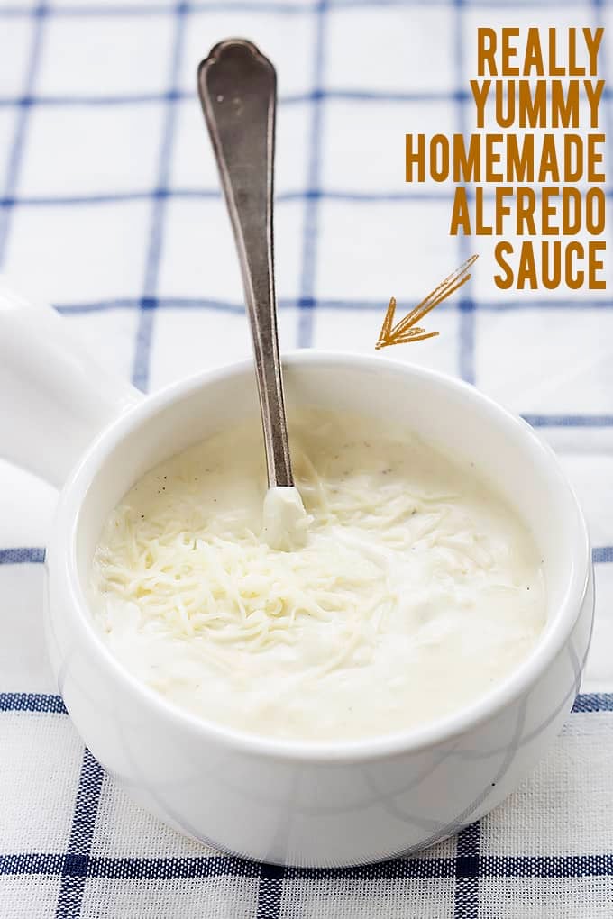 a bowl of homemade alfredo sauce with a spoon and the words "really yummy homemade alfredo sauce" with an arrow pointing to the sauce written on the side.