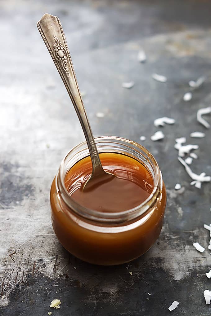 a small jar of caramel with a spoon in it.