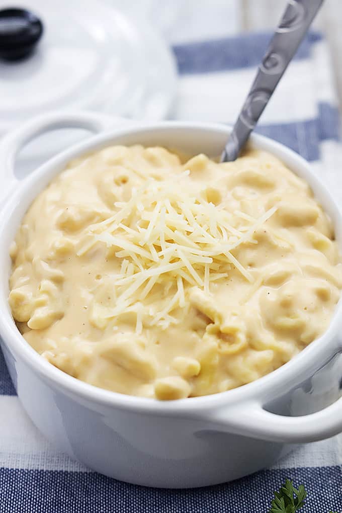 slow cooker 4 cheese macaroni with a spoon in a bowl.