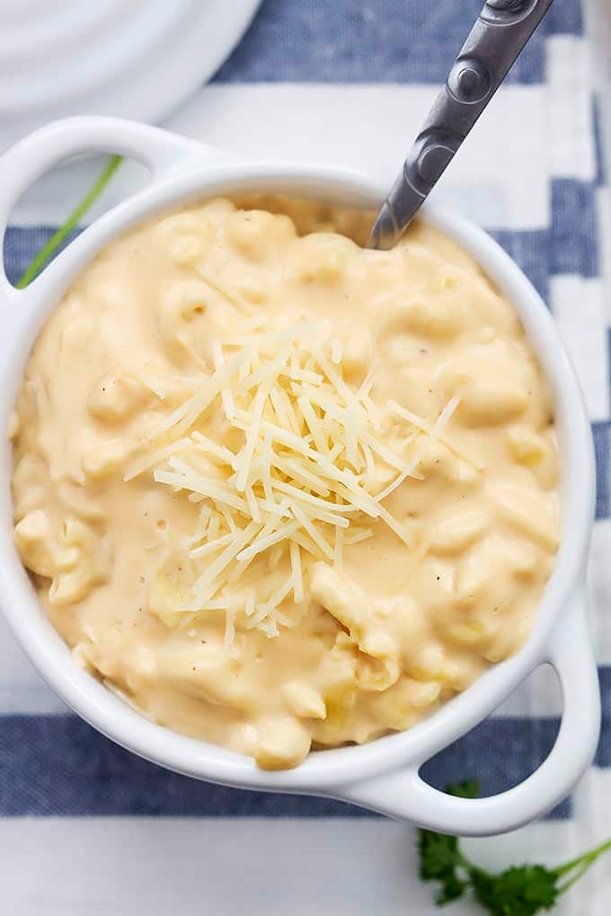 top view of slow cooker 4 cheese macaroni and a spoon in a bowl.