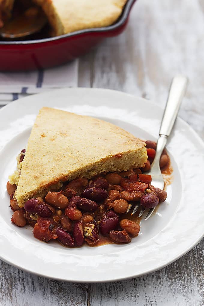 a slice of Chili cornbread skillet pie with a fork on a plate.