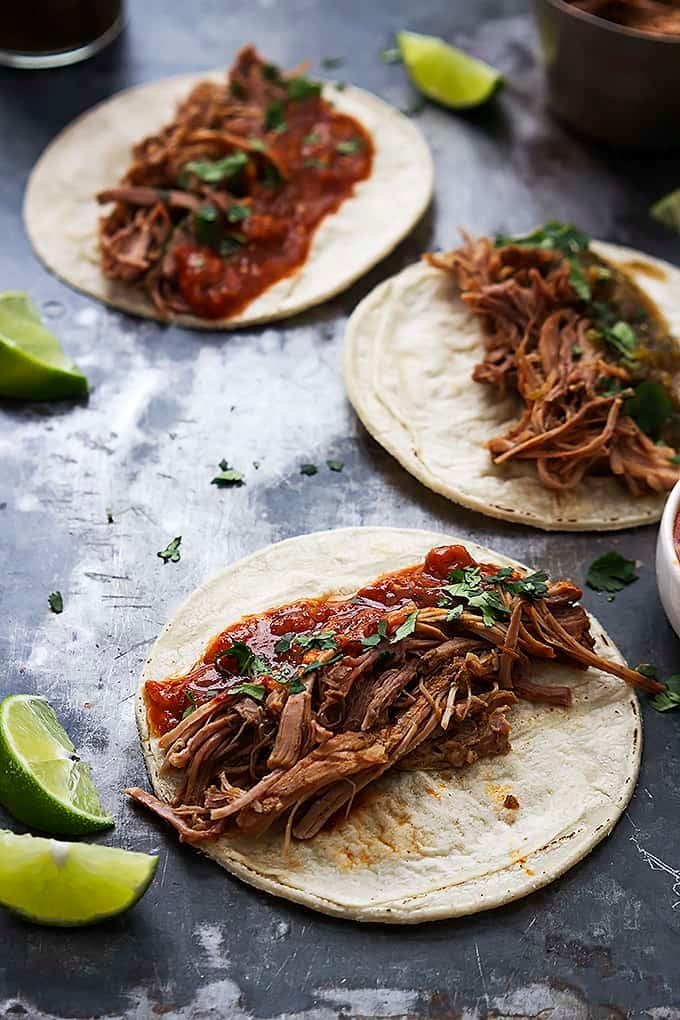 slow cooker pork carnitas with slices of lime on the side.