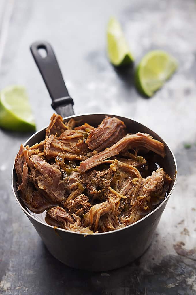 pork in a cooking pot with slices of lime in the background.