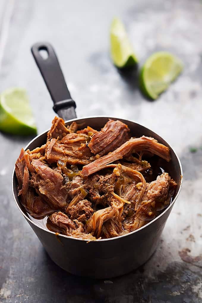 pork in a cooking pot with slices of lime in the background.