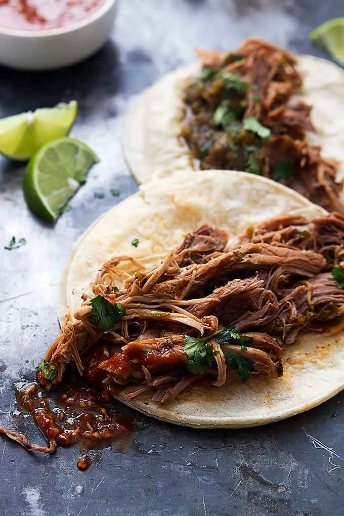 slow cooker pork carnitas with slices of lime on the side.