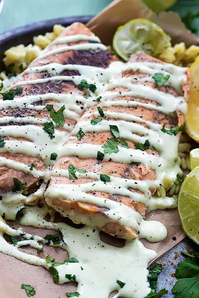 close up of baked salmon with avocado cream sauce.