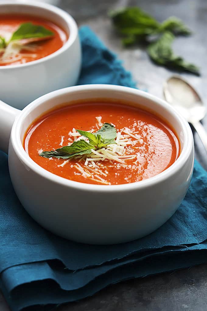 roasted red pepper soup in a bowl with a spoon and another bowl of soup on the side.