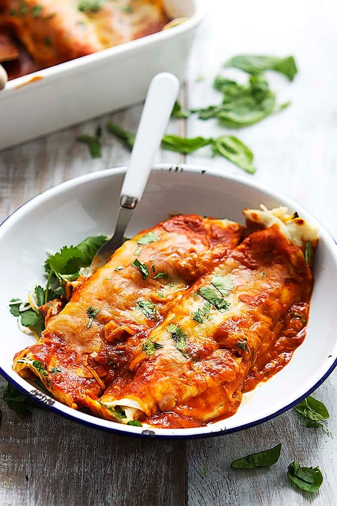 cheesy spinach enchiladas with a fork in a bowl.