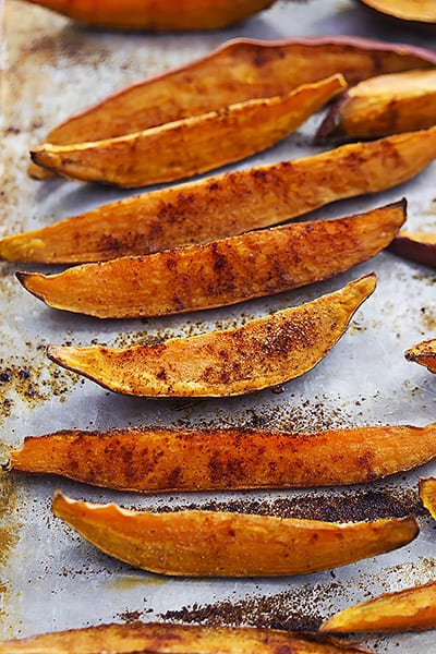 spicy baked sweet potato wedges on a baking sheet.