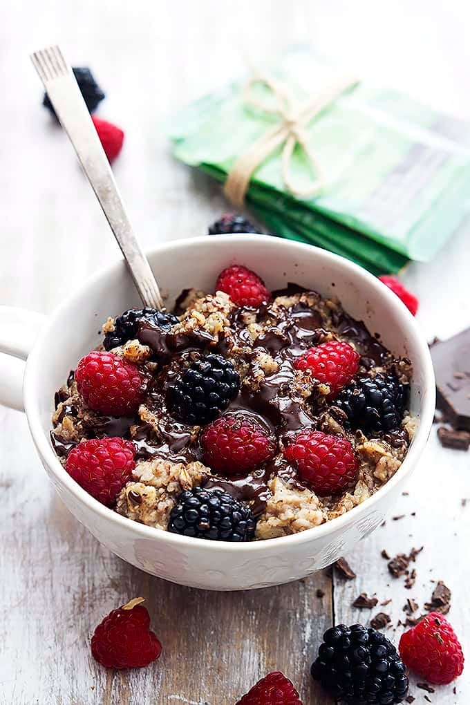 choco-berry oatmeal with berries on top and a spoon in a bowl.
