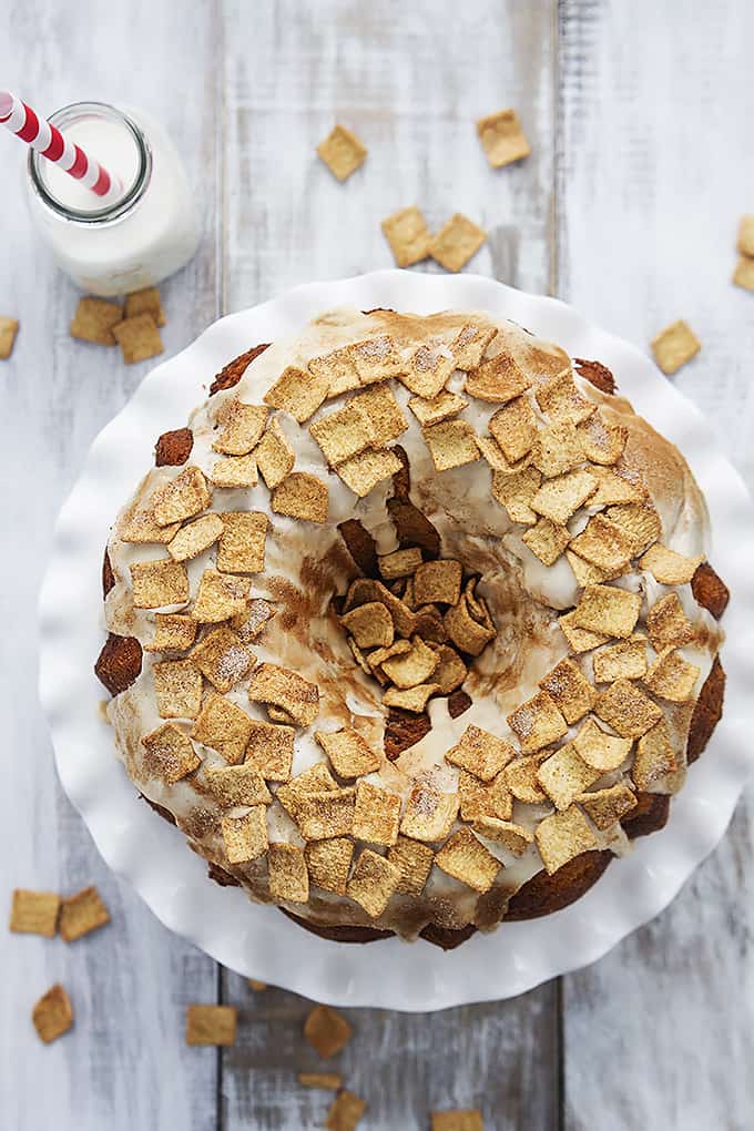 top view of Cinnamon Toast Crunch bundt cake on a cake platter with a jar of milk with a straw on the side.