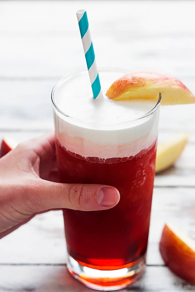 a hand holding a glass of Red's apple slush (Disneyland copycat).