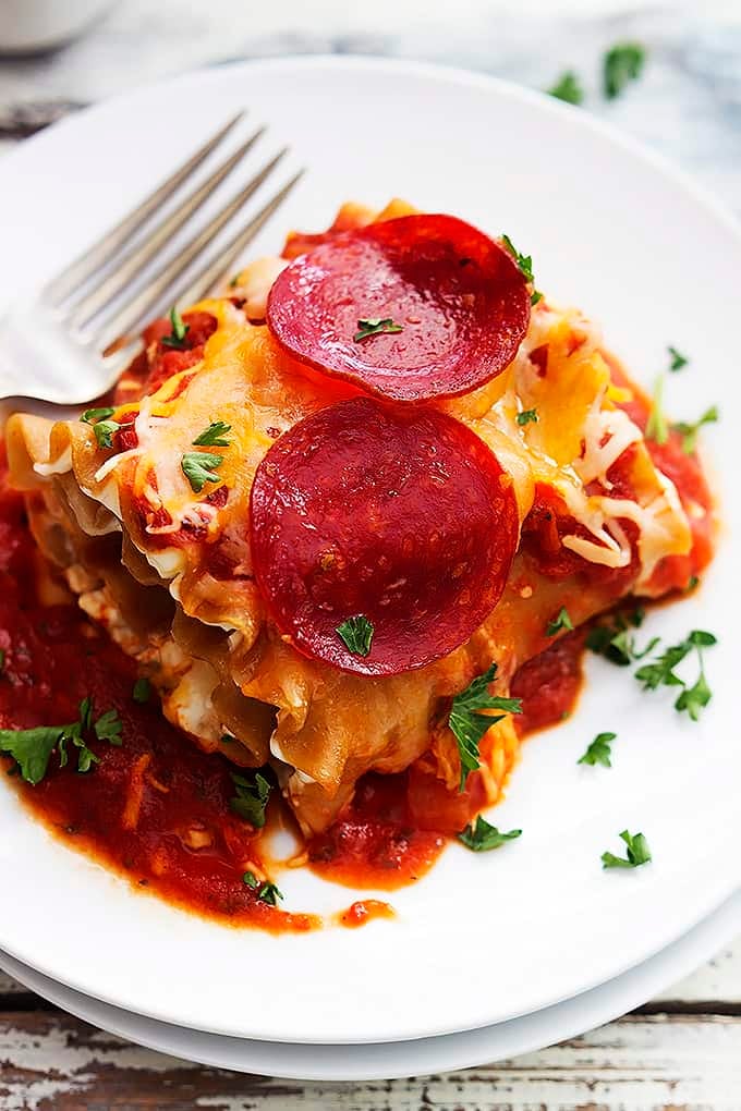a pepperoni pizza lasagna roll up with a fork on a plate.
