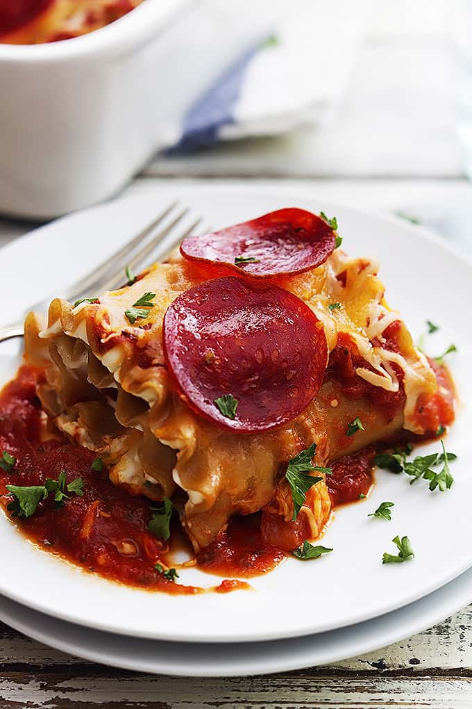 a pepperoni pizza lasagna roll up with a fork on a plate.