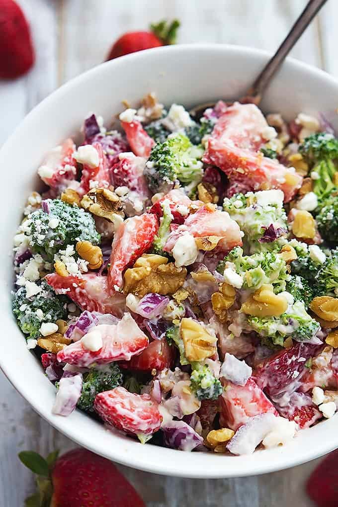 top view of strawberry broccoli salad and a fork in a bowl.