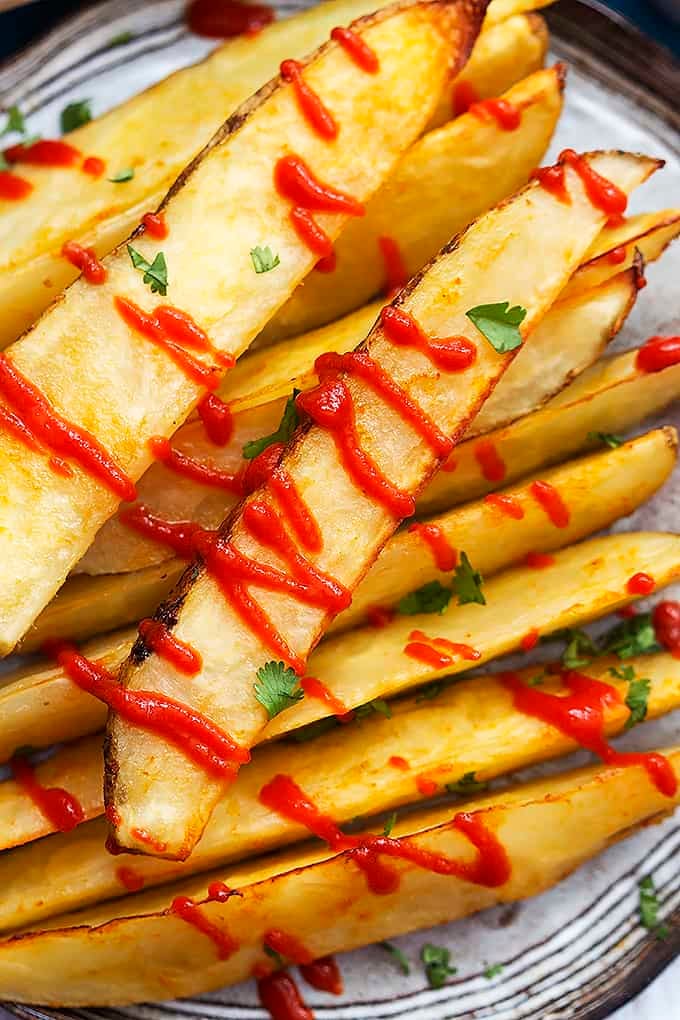 baked garlic sriracha fries with ketchup on top.