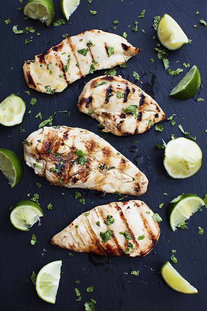 top view of grilled cilantro lime chicken surrounded by lime slices and halves.