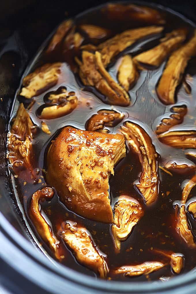 close up of slow cooker honey garlic chicken in a slow cooker. 