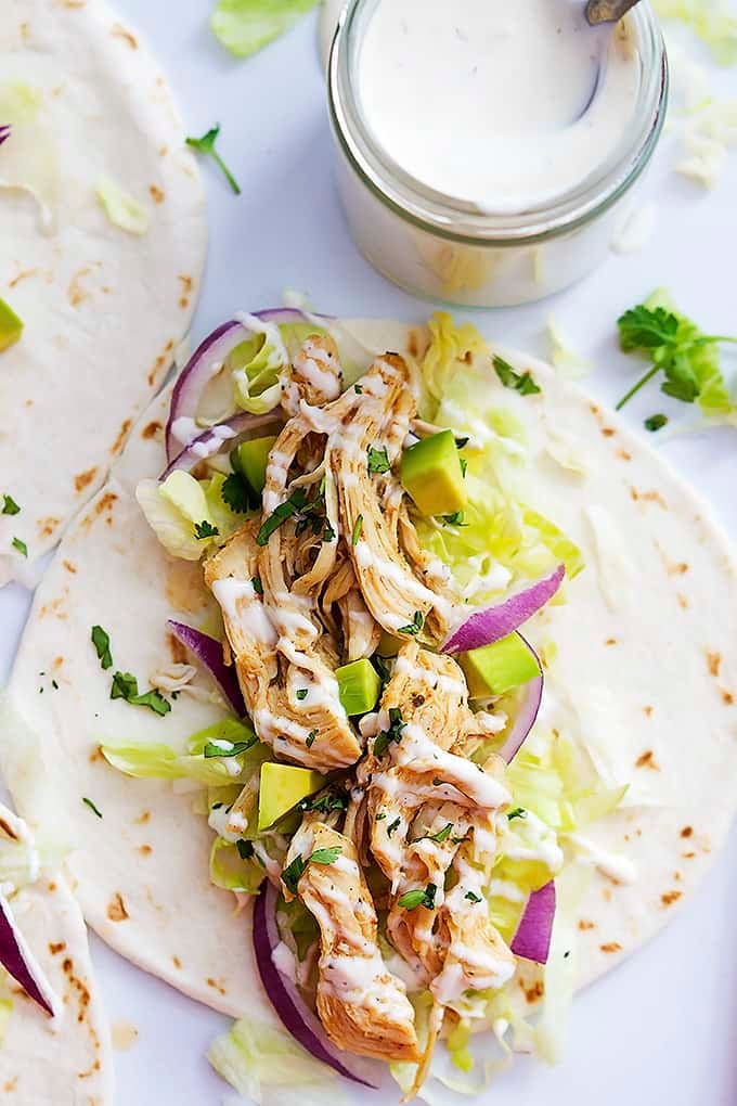 top view of a slow cooker ranch chicken taco with a jar of creamy ranch on the side.