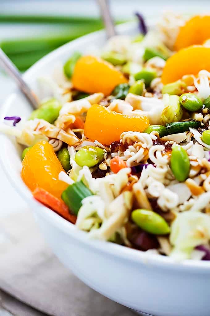 Asian ramen noodle salad in a bowl with two serving spoons.