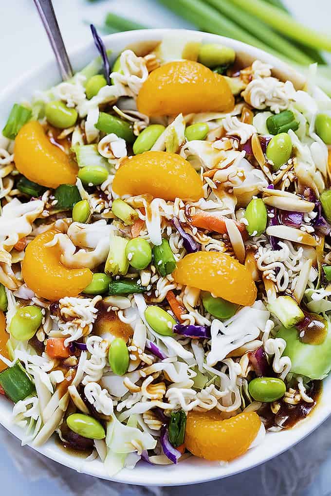 top view of Asian ramen noodle salad with a serving spoon in a bowl.