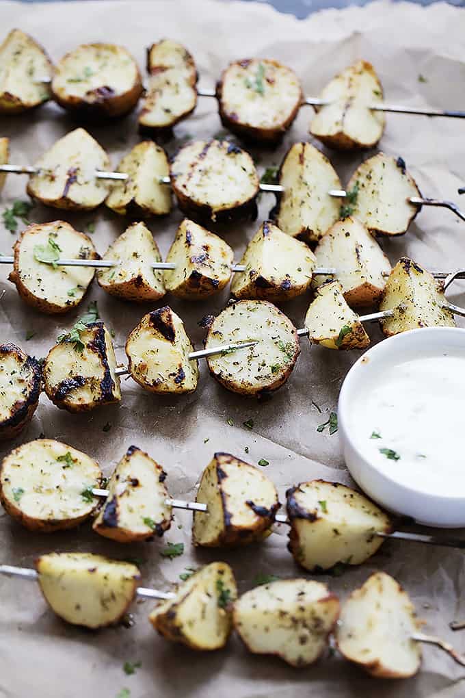 grilled ranch potatoes on skewers with a bowl of ranch on the side.
