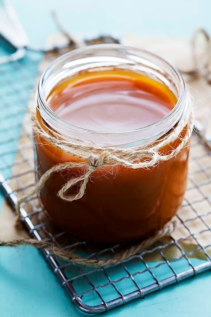 a jar of caramel sauce on a cooling rack.