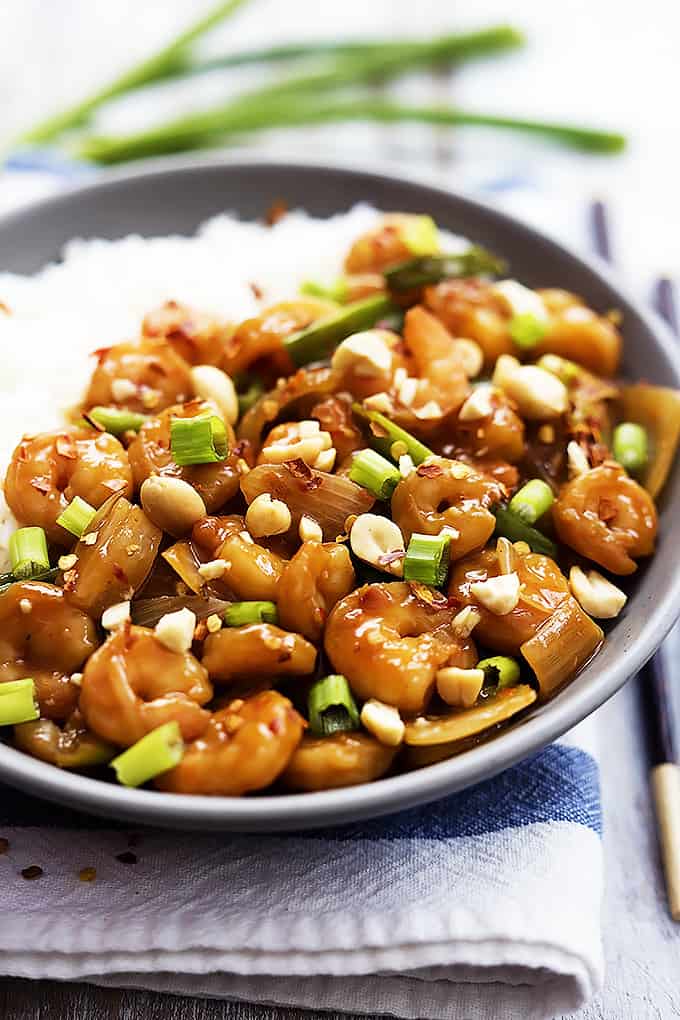 kung pao shrimp with rice on a plate with chopsticks on the side.