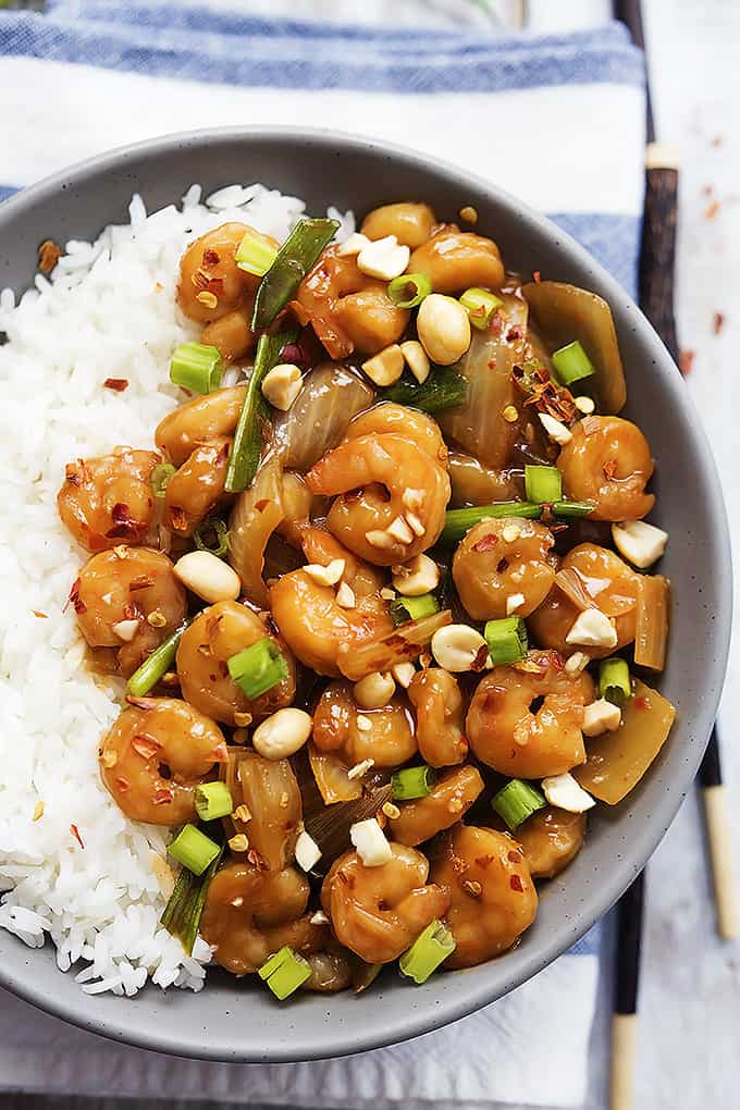 top view of kung pao shrimp and rice on a plate with chopsticks on the side.