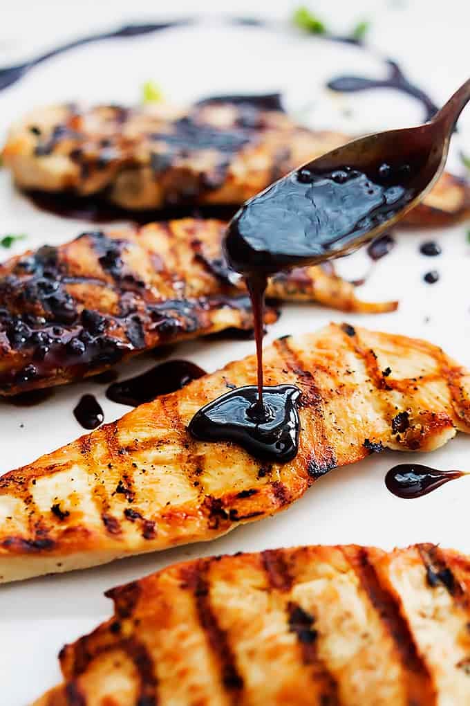 sauce being poured on top of sticky Asian grilled chicken.