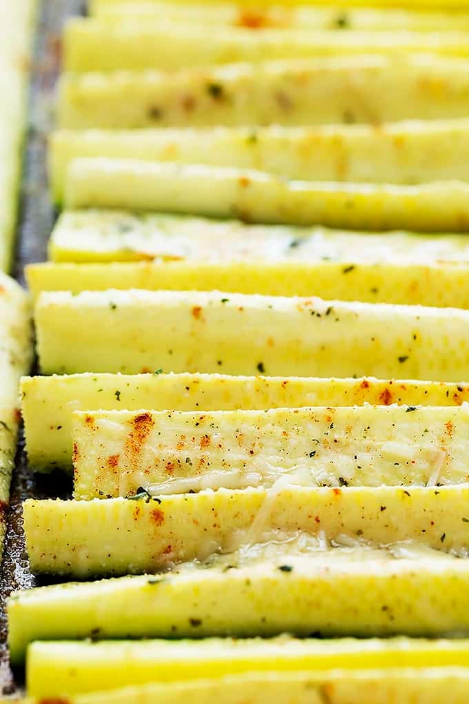close up of baked cheesy ranch zucchini on a baking sheet.