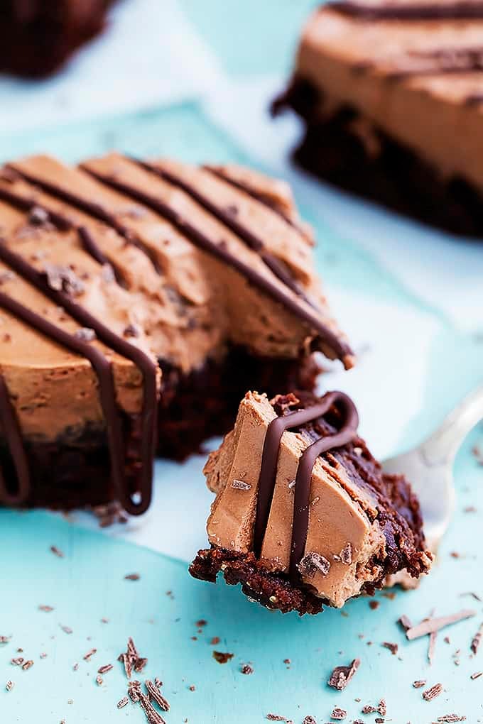 clos cup of a chocolate mousse brownie with a bite of it sitting on a fork in front of it.