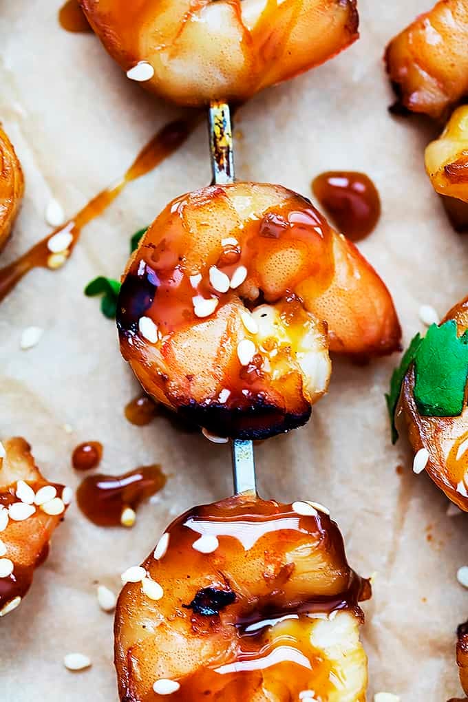 close up of a teriyaki shrimp skewer with more on the side.