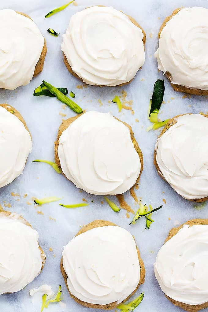 top view of zucchini cookies with brown butter cream cheese frosting with zucchini shavings around them.