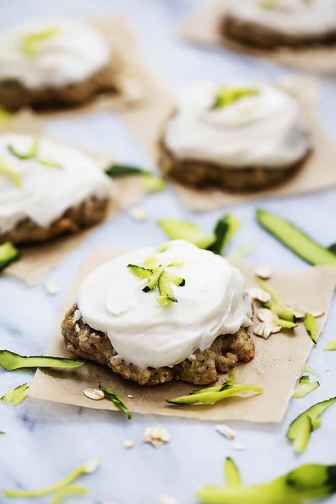 frosted zucchini oatmeal cookies topped and surrounded by zucchini shavings.