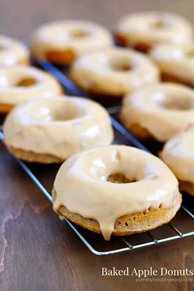 baked apple donuts on a cooling rack with the title of the recipe written on the bottom right corner of the image.