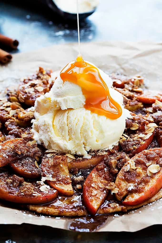 apple crumble flatbread topped with vanilla ice cream with caramel being poured on top.