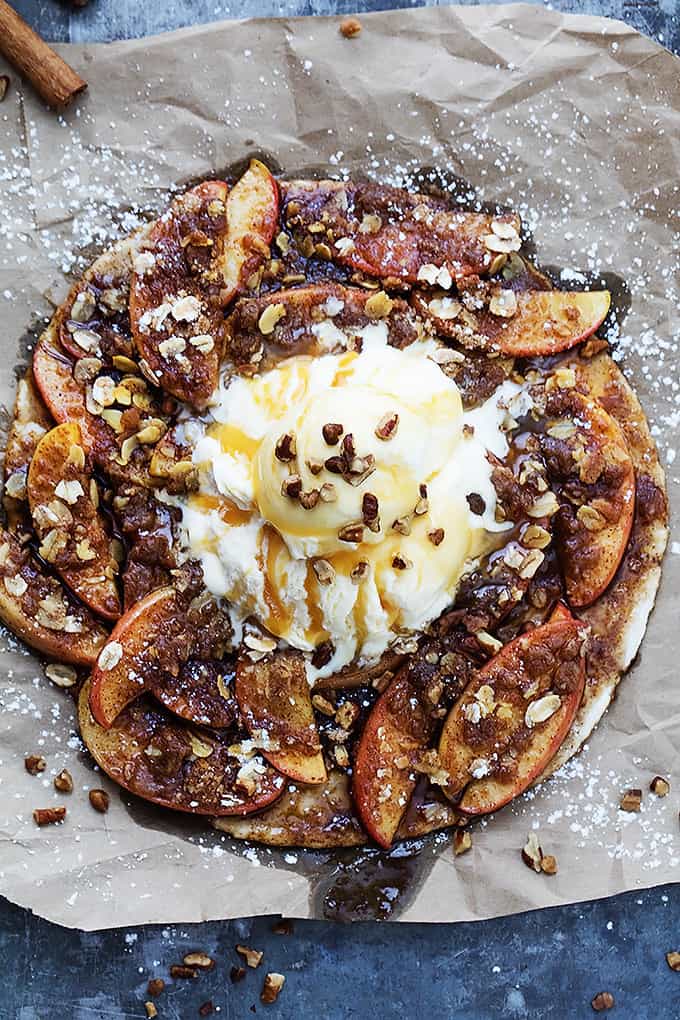 top view of apple crumble flatbread topped with vanilla ice cream, caramel sauce, and nuts.