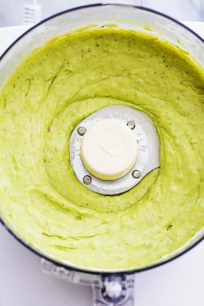 close up top view of zesty avocado sauce in a blender.