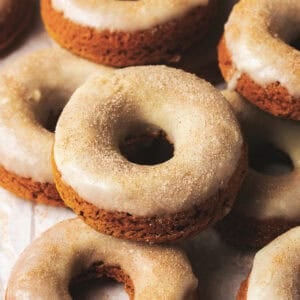 Baked pumpkin donuts stacked in a pile.